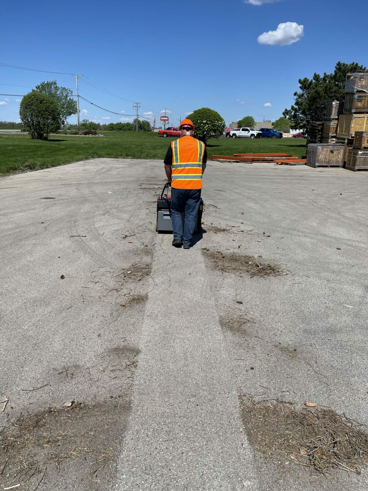 PowerBoss Collector 34 Walk-behind sweeper cleaning dirt in parking lot