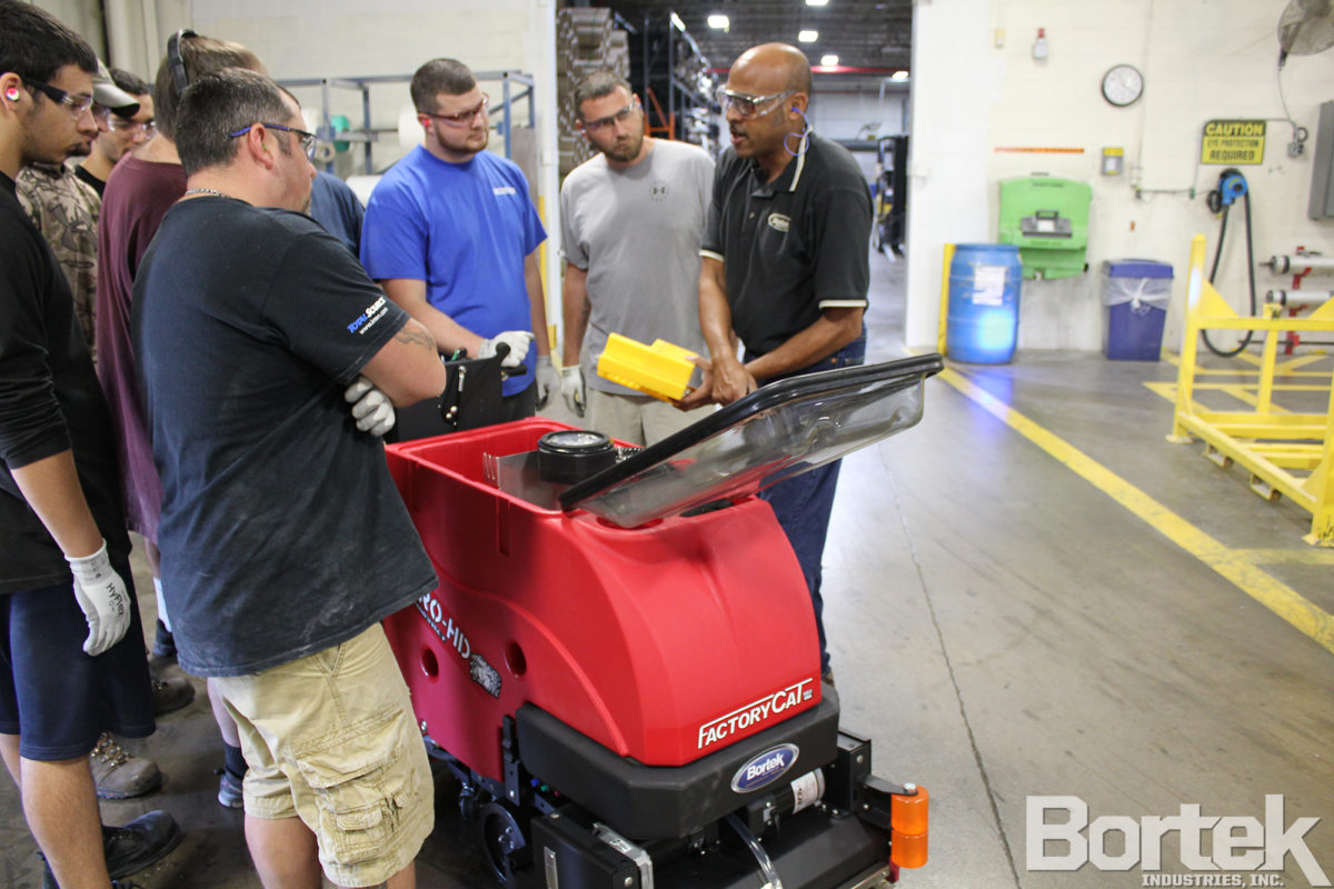 Sales representative trains factory employees to use Micro-HD scrubber