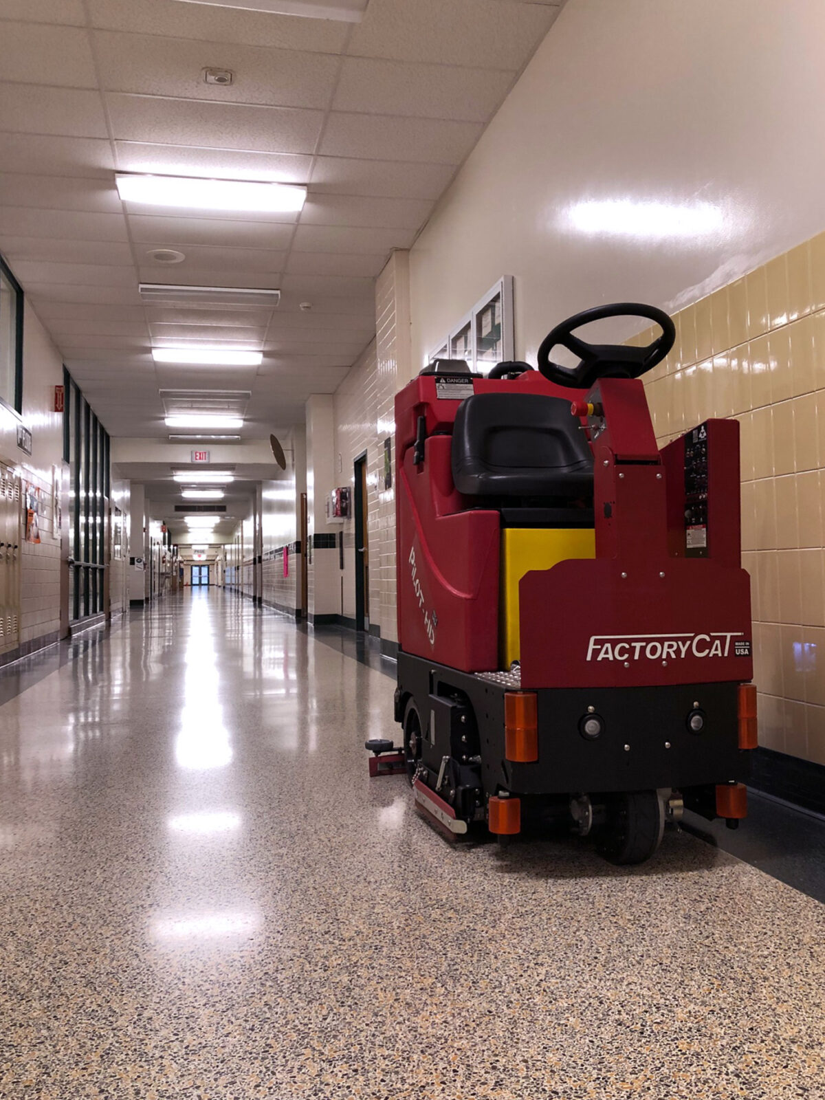 Factory Cat Pilot HD Floor Scrubber cleaning a school hallway
