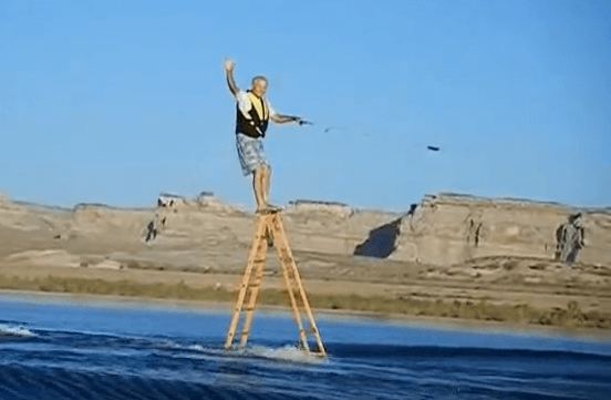 Leroy Wicklund wakeboards on ladder unsafely on top step.