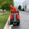 PowerBoss Apex 47 sweeping along a curb in a paved area