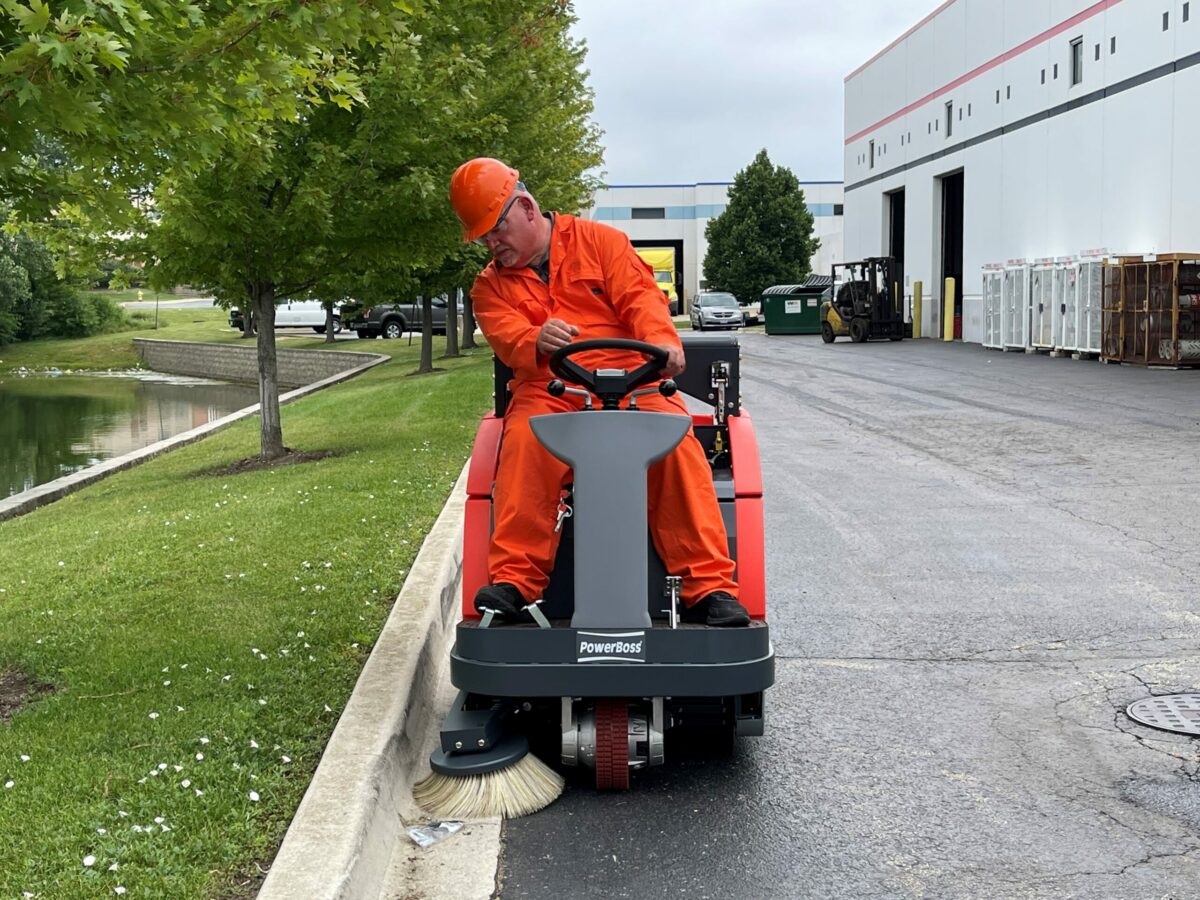 PowerBoss Apex 47 sweeping along a curb in a paved area