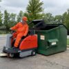 PowerBoss Apex 47 sweeper dumping into a dumpster