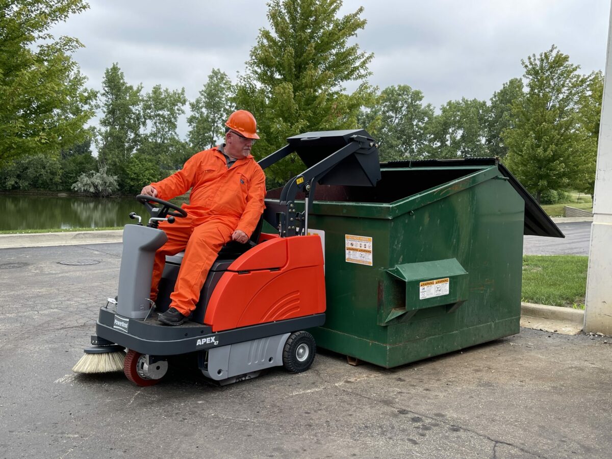 PowerBoss Apex 47 sweeper dumping into a dumpster