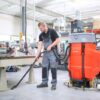 PowerBoss Scrubmaster B120 cleaning factory floor with vacuum accessory