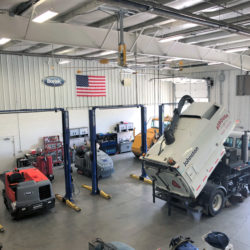 A street sweeper on a lift in Bortek's repair center