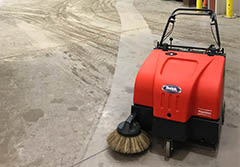 A walk-behind floor sweeper with a clean trail
