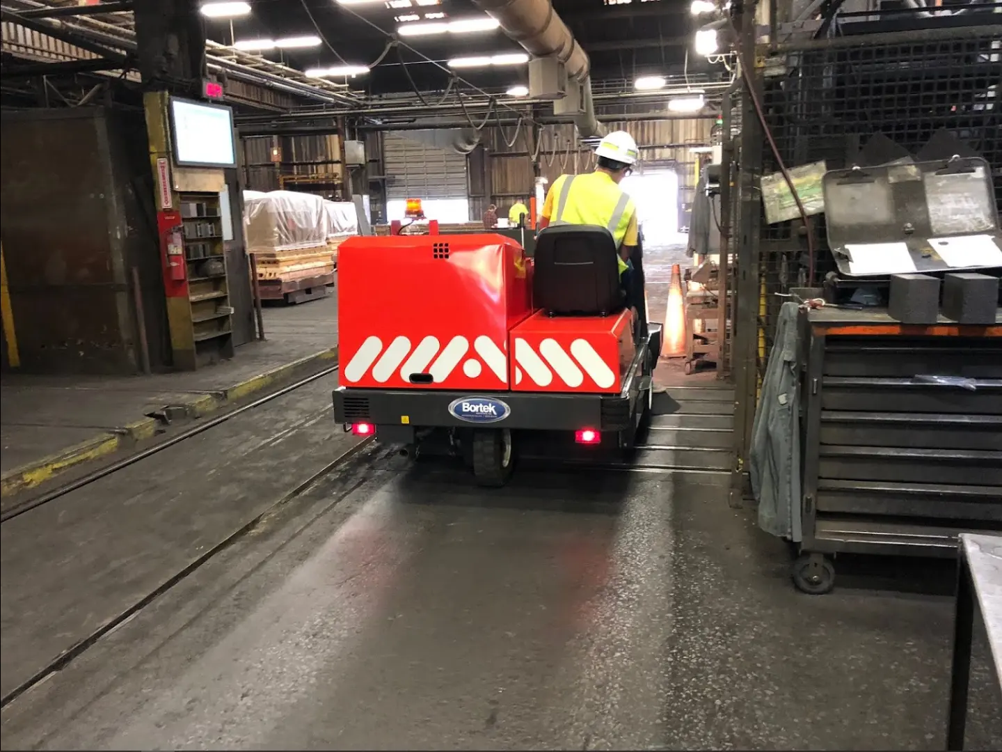 PowerBoss Atlas ride-on industrial floor sweeper in use at a factory